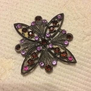 Antique brooch with purple rhinestones.